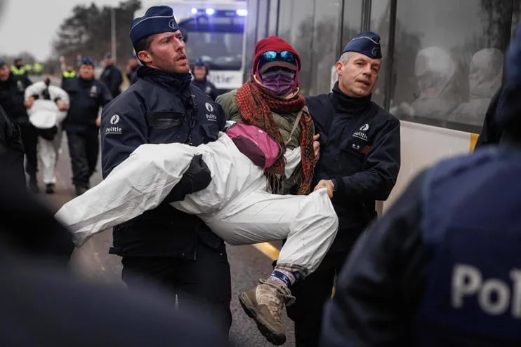 Policías belgas arrestan y se llevan a uno de los activistas del colectivo "Código Rojo" quienes bloquearon dos aeropuertos en el país europeo.