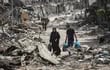 Dos personas caminan entre escombros de edificios destruidos en Jan Yunis, en el sur de la Franja de Gaza.