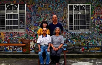 El artista de graffiti hakka Wu Tsun-hsien (arriba, der.) posando con su familia frente a su casa en el pueblo taiwanés de Ruan Chiao.
