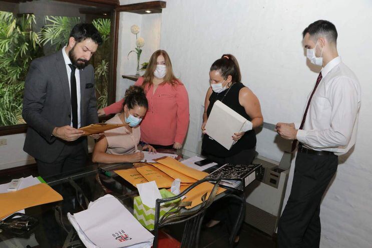 El fiscal Osmar Legal (izq.) y su colega Liliana Alcaraz (camisa rosada) verifican documentos hallados en los allanamientos.