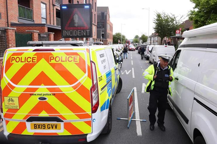 Agentes de policía asisten a la escena del crimen en Hainault, al este de Londres, el 30 de abril de 2024, donde un hombre de 36 años que empuñaba una espada fue arrestado tras un ataque contra miembros del público y dos agentes de policía.