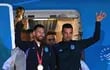 El capitán y delantero argentino Lionel Messi (L) sostiene el Trofeo de la Copa Mundial de la FIFA junto con el entrenador argentino Lionel Scaloni cuando bajan de un avión al llegar al Aeropuerto Internacional de Ezeiza después de ganar el torneo de la Copa Mundial Qatar 2022 en Ezeiza, provincia de Buenos Aires, Argentina en diciembre 20, 2022.