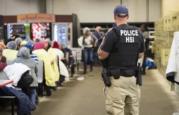 Un policía estadounidense custodia a un grupo de supuestos inmigrantes detenidos.