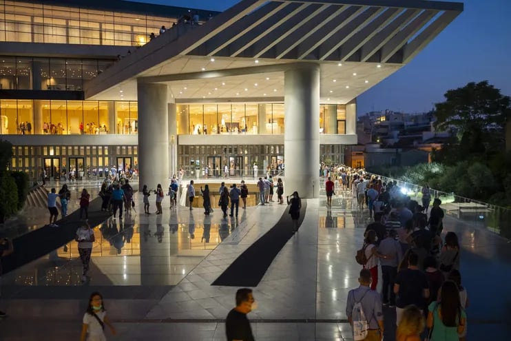 Los visitantes hacen cola para ingresar al Museo de la Acrópolis de Atenas, ya que los museos y sitios arqueológicos abren por la noche durante dos días.