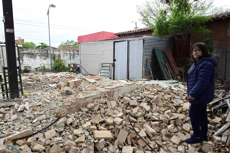 La directora de la escuela básica Delfín Chamorro, Silvia Aranda, posa sobre los escombros que dejó Engineering SA.