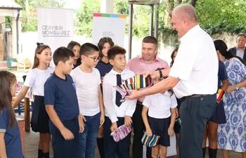 El fiscal general del Estado, Emiliano Rolón, hace entrega de cartucheras textiles a escolares.