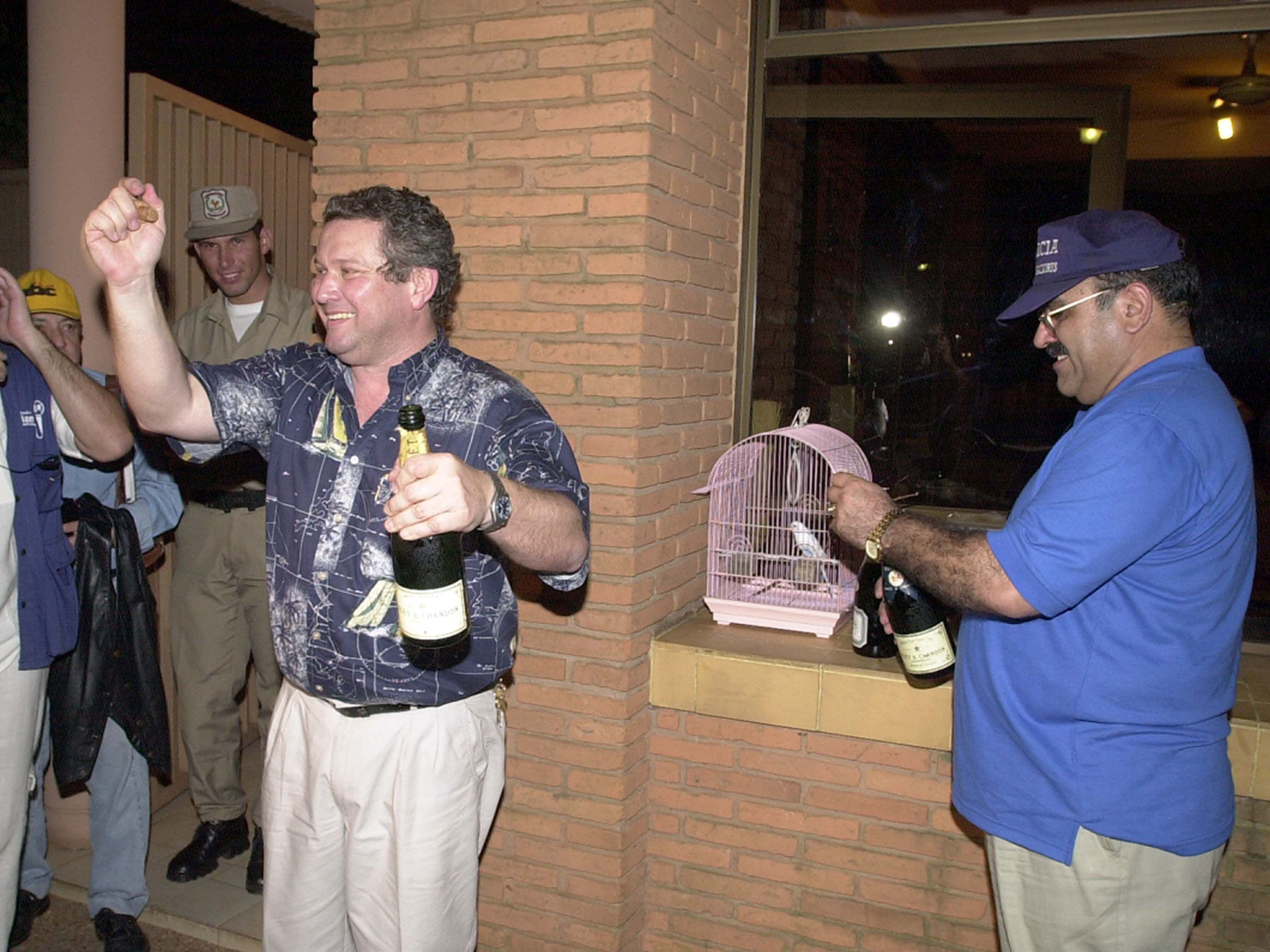 Enzo Debernardi celebra con champagne la liberación de su esposa. Atrás, el comisario Roberto González Cuquejo.