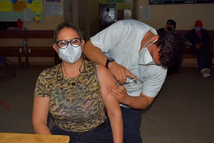 La paciente Carolina Ruiz Díaz (47) al momento de recibir la segunda dosis de la vacuna anticovid a cargo del personal de blanco en el Hospital Regional de Villarrica.