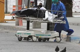 Un enfermero traslada el cuerpo de una víctima de Covid-19, hoy a la morgue del Hospital General de Ciudad Juárez estado de Chihuahua (México).