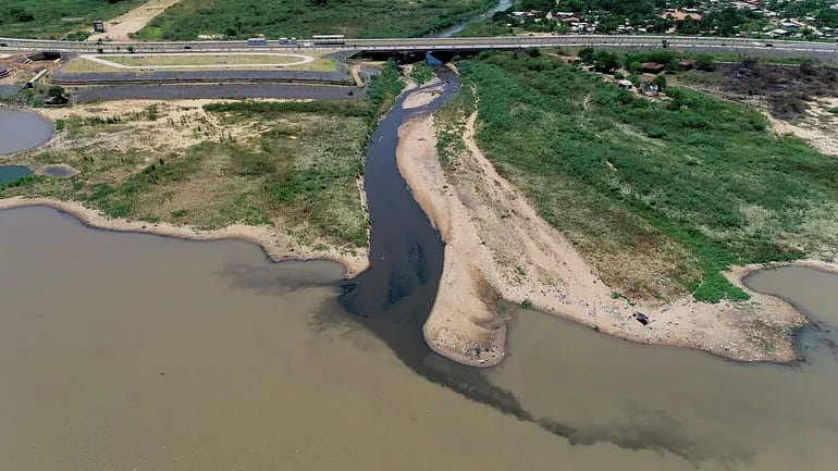 Impunemente se descarga todo tipo de desechos sólidos y efluentes cloacales al Mburicaó. En la foto, se observa el agua turbia del arroyo que desemboca en el río Paraguay.