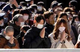 Varias personas con mascariillas rezan en el Templo Meiji, en Tokio, en enero de este año.