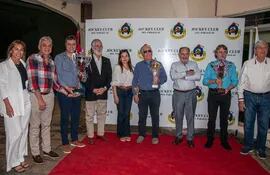Los propietarios de los pingos ganadores de la jornada en conmemoración al aniversario del Hipódromo, con sus copas.