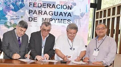 Luis Tavella (i), de Fedemipymes, firma el acuerdo con Miguel Zayas, Víctor Insfrán y Reinaldo Barreto, de centrales obreras.
