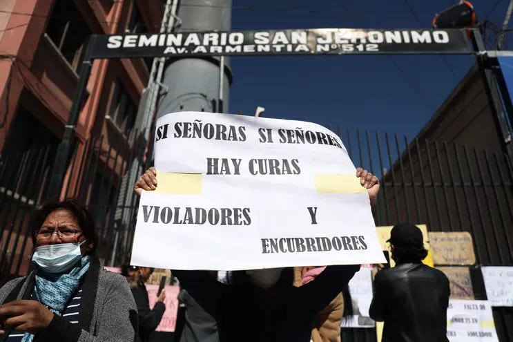 Varias personas protestan en contra de la Iglesia católica pegando carteles en las puertas del seminario San Jerónimo, en La Paz (Bolivia). Foto de archivo de mayo del 2023.