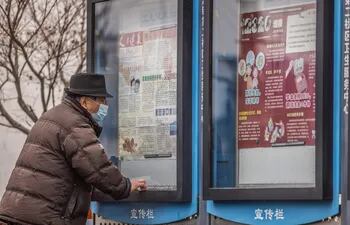 Un hombre mira un panel de información sobre Covid-19 frente a un hospital en Shanghai, China.