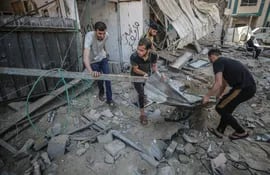 Palestinos inspeccionan su casa destruida después de los ataques aéreos israelíes en el campo de refugiados de Jabaliya, en el norte de la Franja de Gaza