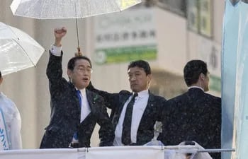 El primer ministro japonés Fumio Kishida (izquierda), custodiado por agentes de seguridad, dando un discurso de campaña durante un evento de campaña en la estación Motoyawata en Ichikawa, Prefectura de Chiba, al este de Tokio, Japón.