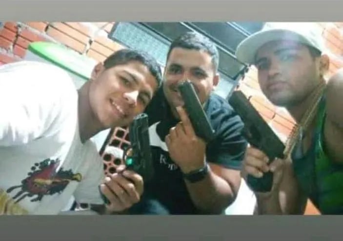 En medio, Valentín Domínguez ostentando una pistola calibre 9 mm junto con otras dos personas, también armadas.