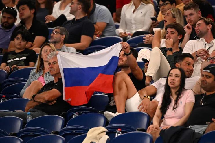 Un ciudadano sostiene la bandera de Rusia durante el día 1 del torneo de tenis Australian Open en Melbourne.