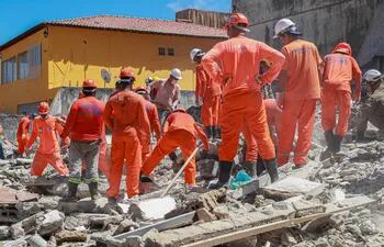 Bomberos trabajan en labores de rescate en el área donde un edificio se desplomó, en Olinda (Brasil).