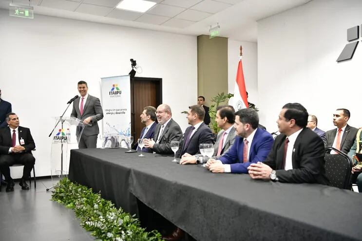 En el extremo derecho de la mesa, el Ing. Félix Sosa, observa al presidente de la República, Santiago Peña, durante su discurso en la toma de posesión de cargo del director paraguayo de Itaipú.