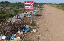 Al costado del camino en la ciudad de Alberdi, está llena de basuras, en contraste con el cartel que indica prohibido arrojar basura.