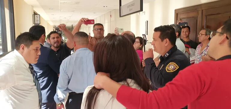Elvio Barúa (de frente, a la izquierda) grita a la abogada Amambay Ferreira, en los pasillos del Poder Judicial.