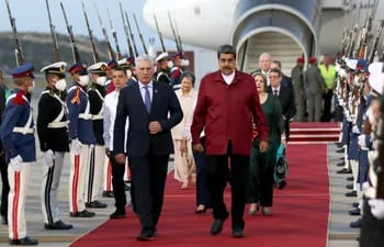 Presidente cubano Miguel Diaz-Canel (L) el presidente venezolano Nicolas Maduro (R) caminando luego de la llegada de Diaz-Canel en el aeropuerto de Maiquetia, Venezuela.