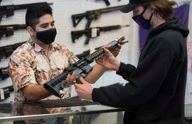 Un cliente inspecciona un rifle de asalto en una tienda de armas en Orem, Utah (Estados Unidos).