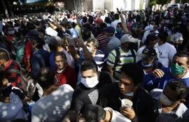 Salvadoreños hacen fila para reclamar un bono para alimentación este lunes.