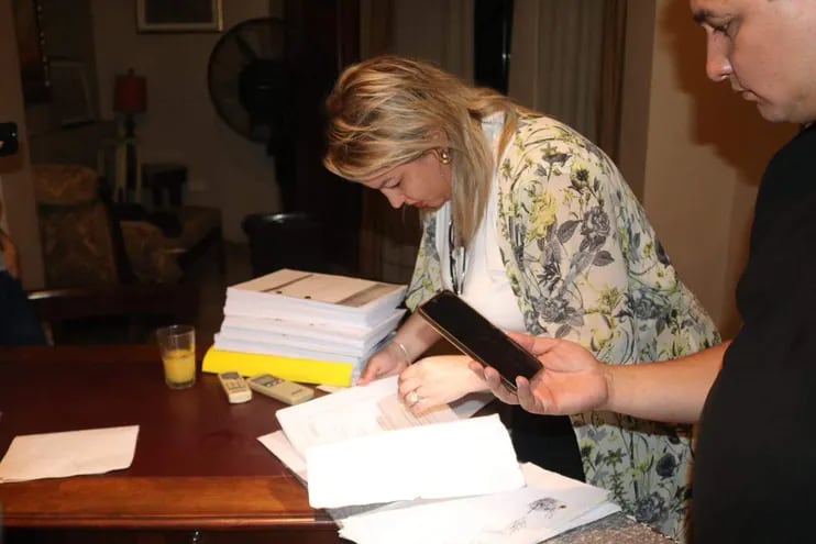 La fiscal Sandra Ledesma inspecciona documentos incautados durante los allanamientos.