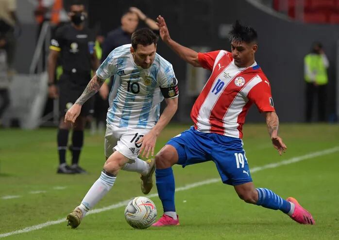 Santiago Arzamendia disputa el balón con Lionel Messi, durante la última Copa América de Brasil 2021.