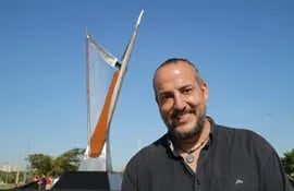 Juan Pablo Pistilli Miranda posa delante de su obra artística en homenaje al arpa paraguaya y al músico y compositor Félix Pérez Cardozo.