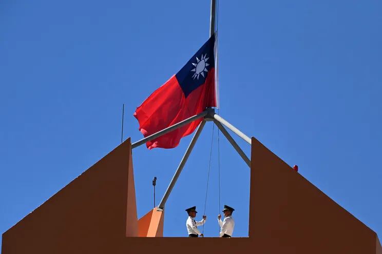 Personal militar de la embajada de Taiwán en Honduras comenzaron a arriar su bandera nacional.  (AFP)