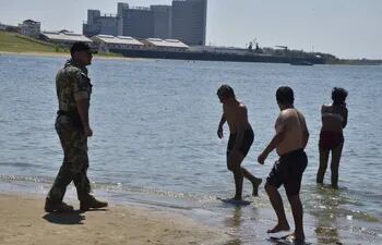 Un militar del Palacio de López retirando a una familia de las aguas contaminadas.