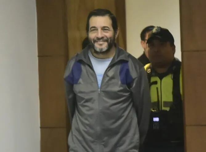 El médico cirujano Miguel Ángel Cavallo, ingresa sonriente a la sala de juicios.