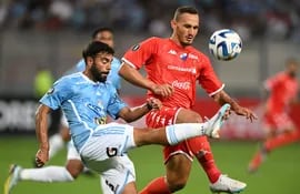 Leandro Sosa trata de llevar el balón ante la marca de Willian Candia en el partido que se juega en el Nacional de Lima