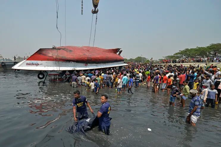 Rescatistas sacan un cuerpo del agua luego del naufragio de un ferry en el río Shitalakhsya, en Bangladés, este lunes.