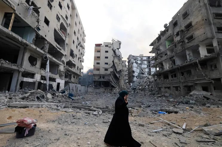 Una mujer camina entre los escombros de edificios destruidos por bombardeos israelíes en la Ciudad de Gaza, este martes.