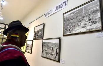 Un hombre mira varias de las fotografías inéditas de la ciudad prehispánica de Tihuanaco en exhibición en La Paz (Bolivia).