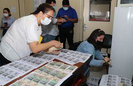 Los asistentes del fiscal Silvio Corbeta realizan la verificación de los billetes, previamente registrados, que fueron entregados a cambio de lograr una salida procesal.