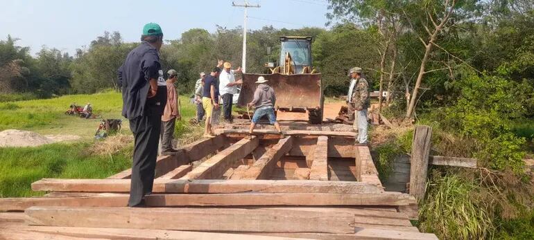 Un grupo de pobladores trabaja en la reparación de la pasarela de madera ubicada sobre el arroyo Tapiracuai del municipio de Santaní.