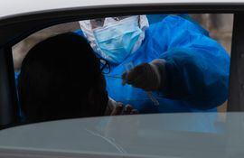 Un trabajador médico toma una muestra de una persona para una prueba de covid-19 frente al Congreso de Uruguay, en Montevideo.