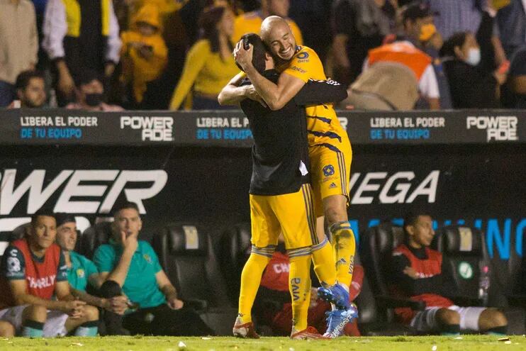 Carlos González celebra con un compañero tras anotar el gol de Tigres