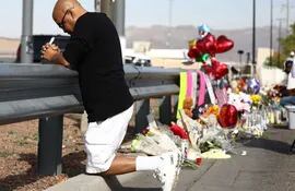 Un hombre reza junto a ofrendas florales cerca del lugar de la matanza en El Paso.
