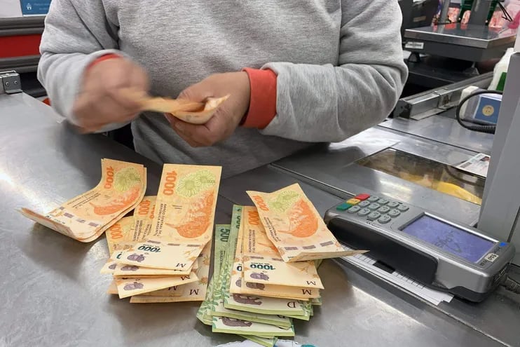 Cajero cuenta pesos argentinos en un comercio.