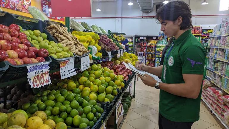 Un estudiante verifica los precios de las frutas en un supermercado de Ciudad del Este.