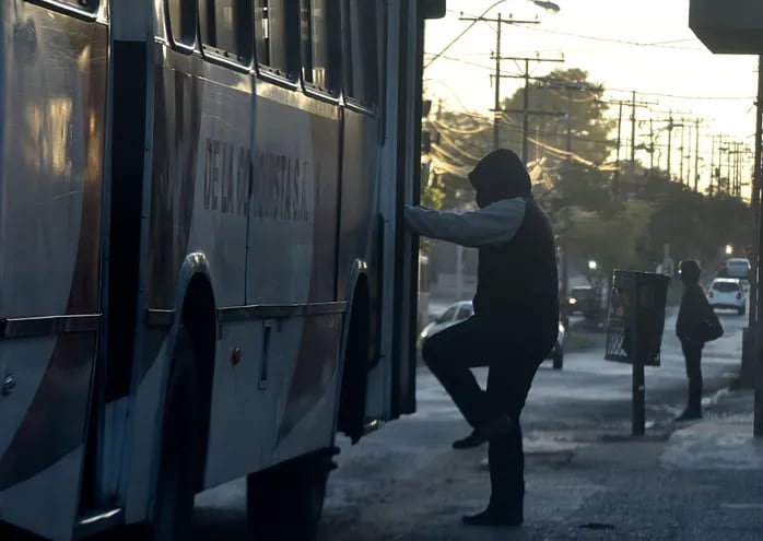 Un hombre sube a un colectivo sobre la avenida Artigas de Asunción en la mañana del miércoles 2 de junio de 2021. Pese a que los transportistas lo niegan, las reguladas del transporte público siguen vigentes y las paradas se llenan de pasajeros que esperan un bus.
