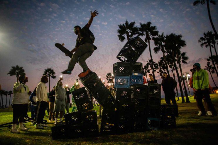 Un hombre cae de una pila de cajas, como parte del desafío de Internet #MilkCrateChallenge, en Venice, California.