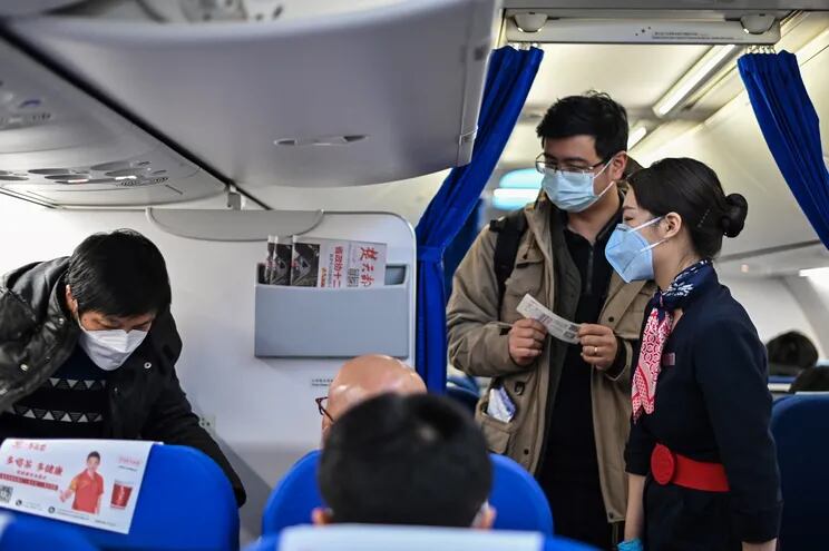Pasajeroscon mascarillas en un avión en el aeropuerto Hongqiao de Shanghai, China.
